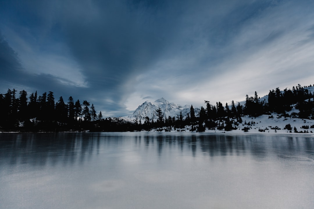 overlooking view of mountain under nimbus clouds, Frozen lake on a winter day