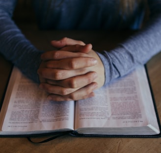 man holding his hands on open book