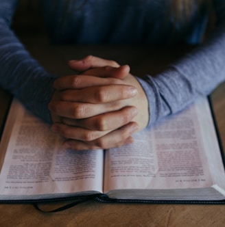 man holding his hands on open book