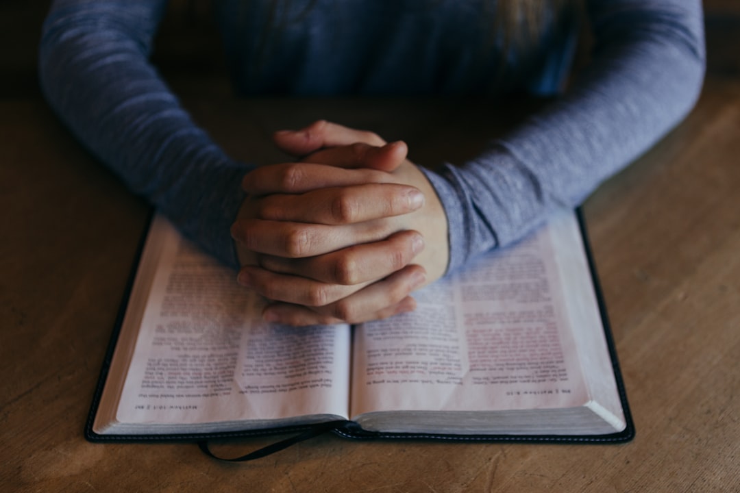 foto cristã orando sobre a bíblia