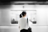 woman in white elbow-sleeved shirt standing near white train in subway