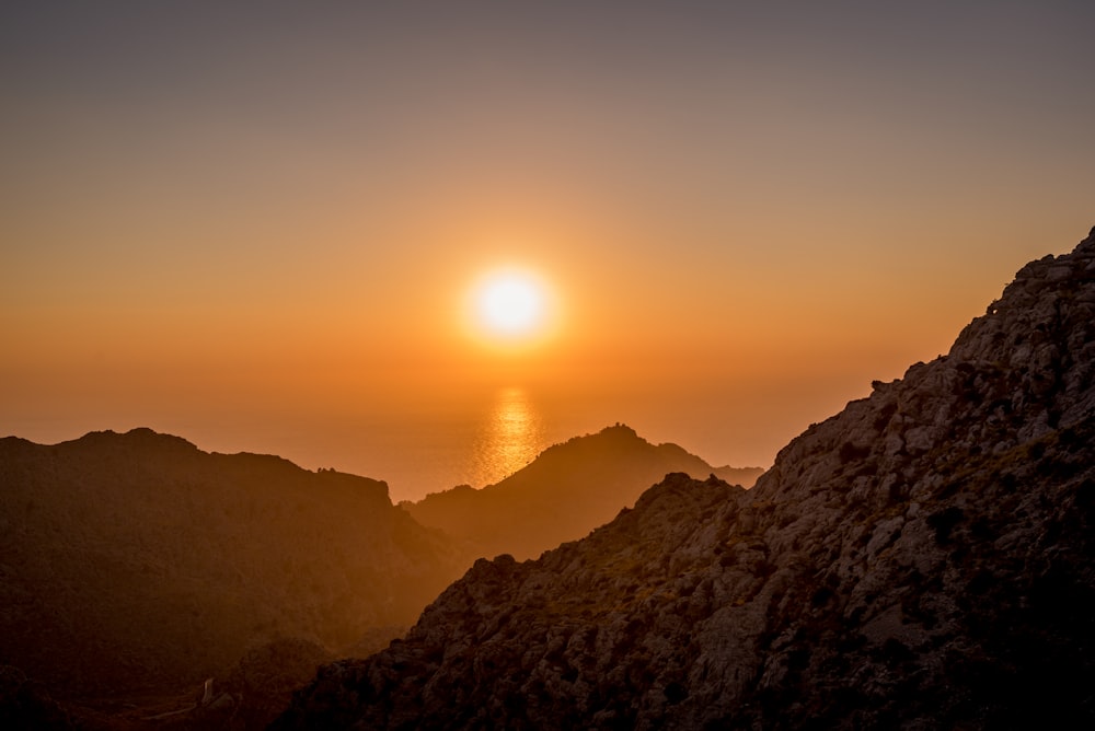 Foto da paisagem das montanhas marrons perto do corpo de água