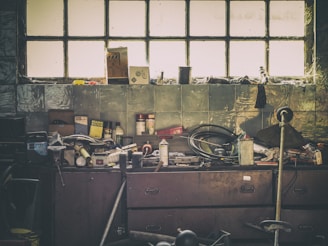 A weathered workbench cluttered with vintage electronic tools and circuit boards, bathed in warm afternoon light.
