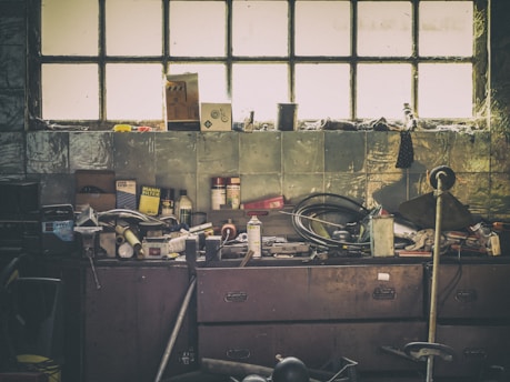 A weathered workbench cluttered with vintage electronic tools and circuit boards, bathed in warm afternoon light.