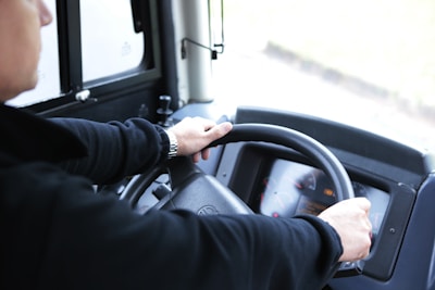 A person holding a learner's permit with a car dashboard in the background.