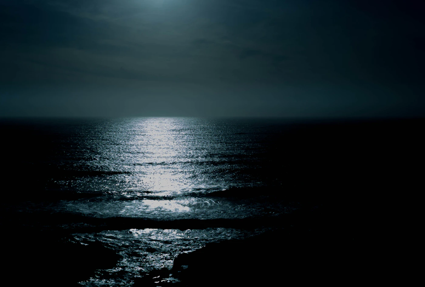 Full moon reflected on a dark, still body of water at night