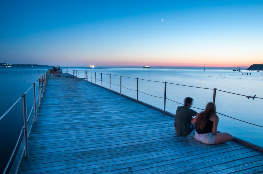 couple sitting on bridge