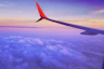person in a plane flying at high altitude taking photo of left airplane wing during daytime