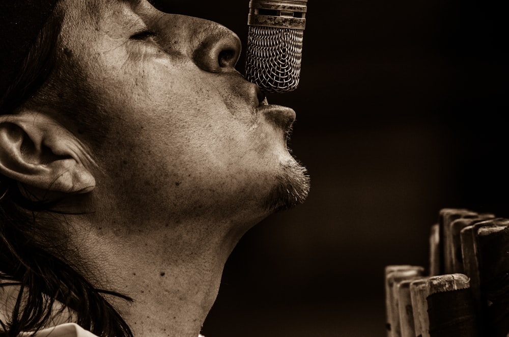man singing with microphone grayscale photography