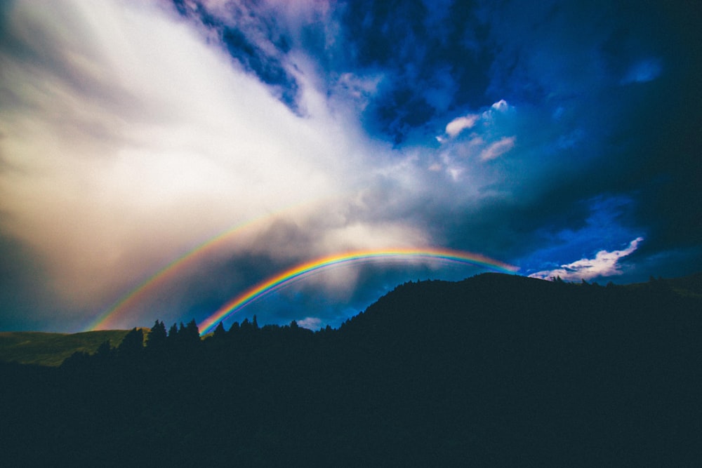 Ilustração do arco-íris sobre a montanha