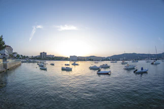 A serene marina at sunset with boats gently rocking on calm water.