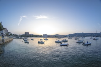 A serene marina at sunset with boats gently rocking on calm waters.