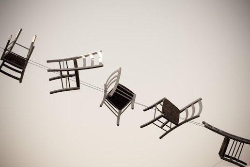 five brown wooden chairs bound in line as a theme