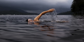 man swimming on body of water