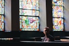man sitting on pew chair