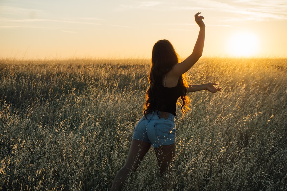 夕暮れ時に緑の芝生で踊る女性