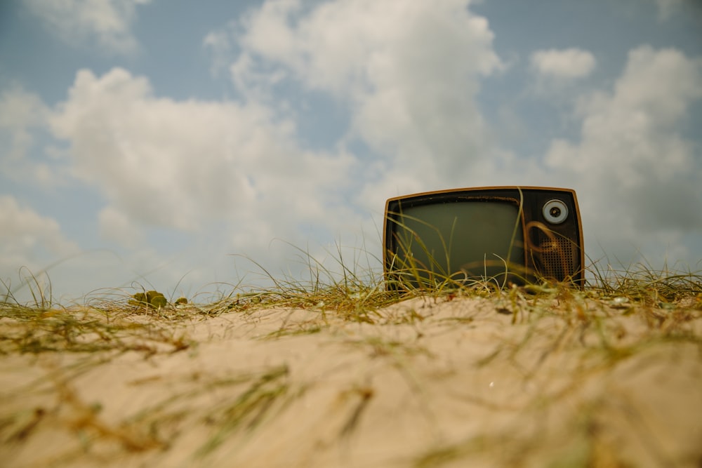 vintage black and brown TV on brown soil at daytime