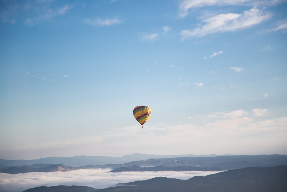 yellow and green hot air balloon floating on air during daytime