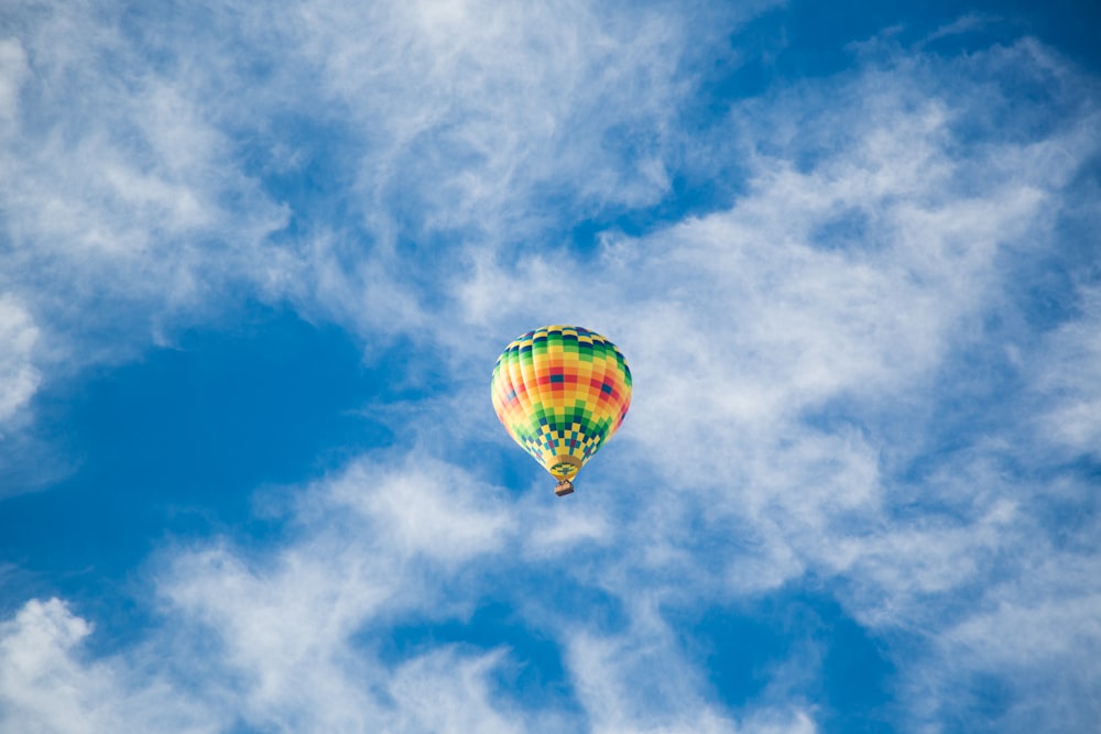 yellow, green, and black hot air balloon on sky
