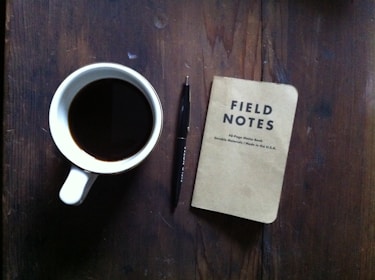 A neat workspace with a ledger book, pen, and a cup of coffee, symbolizing focused bookkeeping.