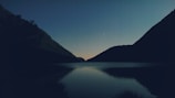A serene lake at twilight, with a mysterious creature emerging.