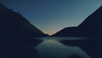Evening shot of the walkers resting by the lake, reflecting on the day’s encounters under soft twilight.