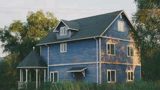 Elegant and inviting exterior view of a blue-soft themed vacation house nestled in lush greenery.