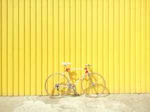 white and red hardtail bike on yellow wall