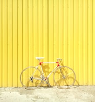 white and red hardtail bike on yellow wall