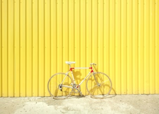 white and red hardtail bike on yellow wall