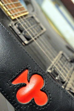 Close-up of electric guitar with red and black background.