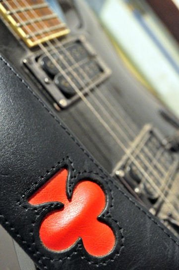 Close-up of a black rock band t-shirt with a vintage guitar graphic and distressed print.