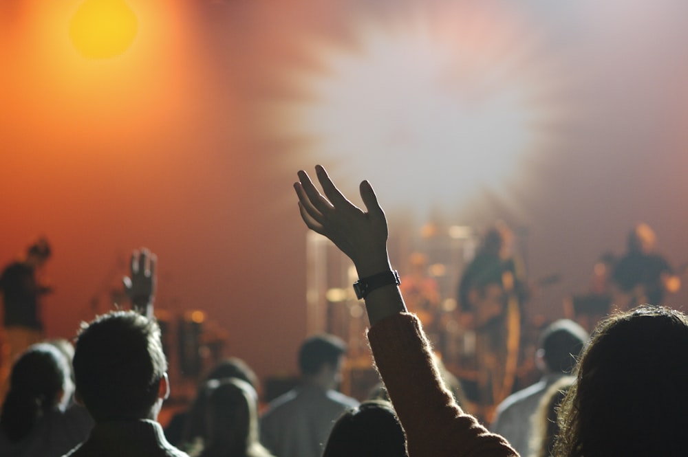 shallow focus photography of hand and people