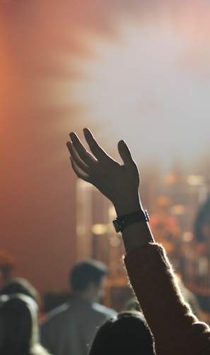 shallow focus photography of hand and people