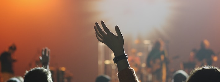 shallow focus photography of hand and people