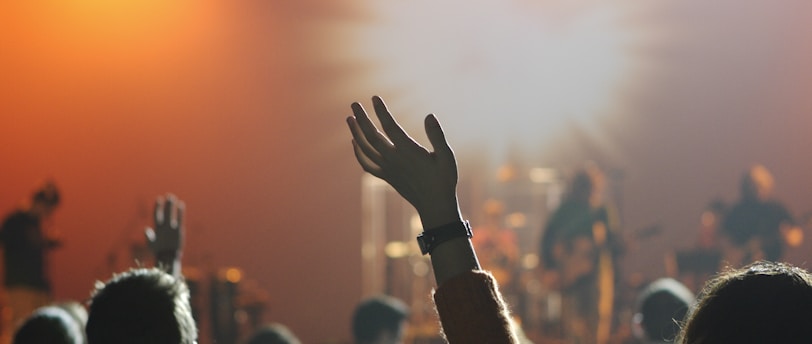 shallow focus photography of hand and people