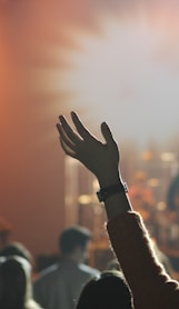 shallow focus photography of hand and people