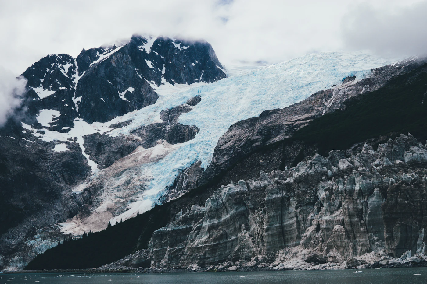 Ein tidewasserndes Gletschertor kalbt Eis in eine Bucht der Kenai Fjords