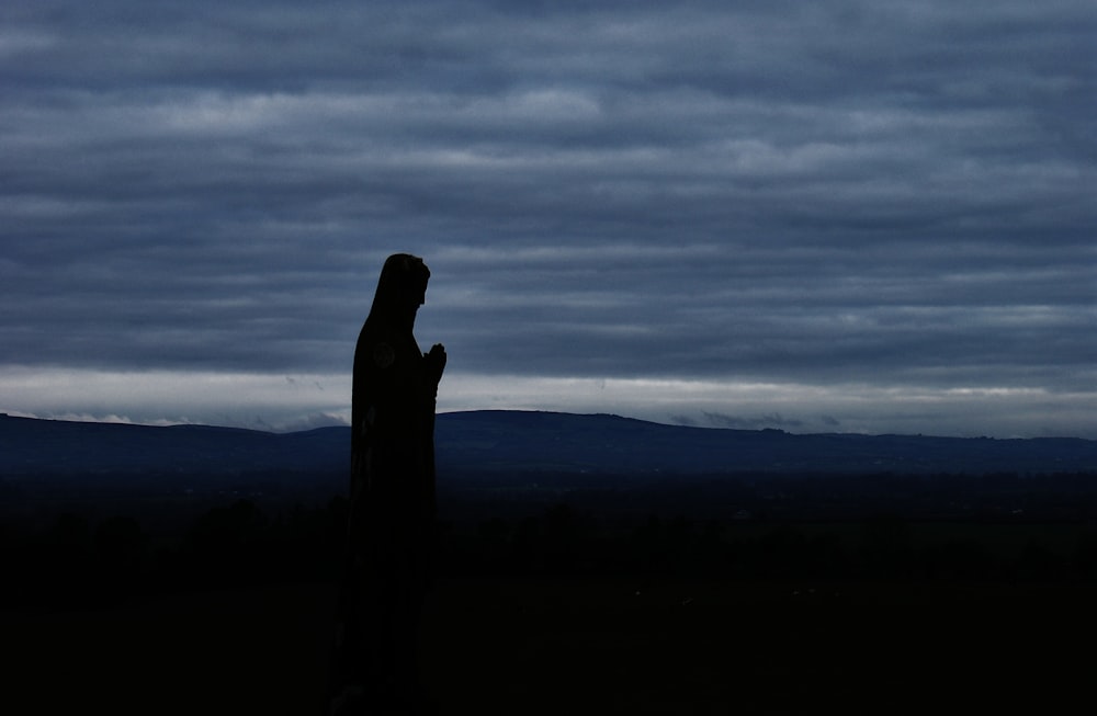 Silhouette einer Person unter bewölktem Himmel