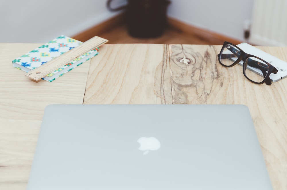 silver MacBook on beige table