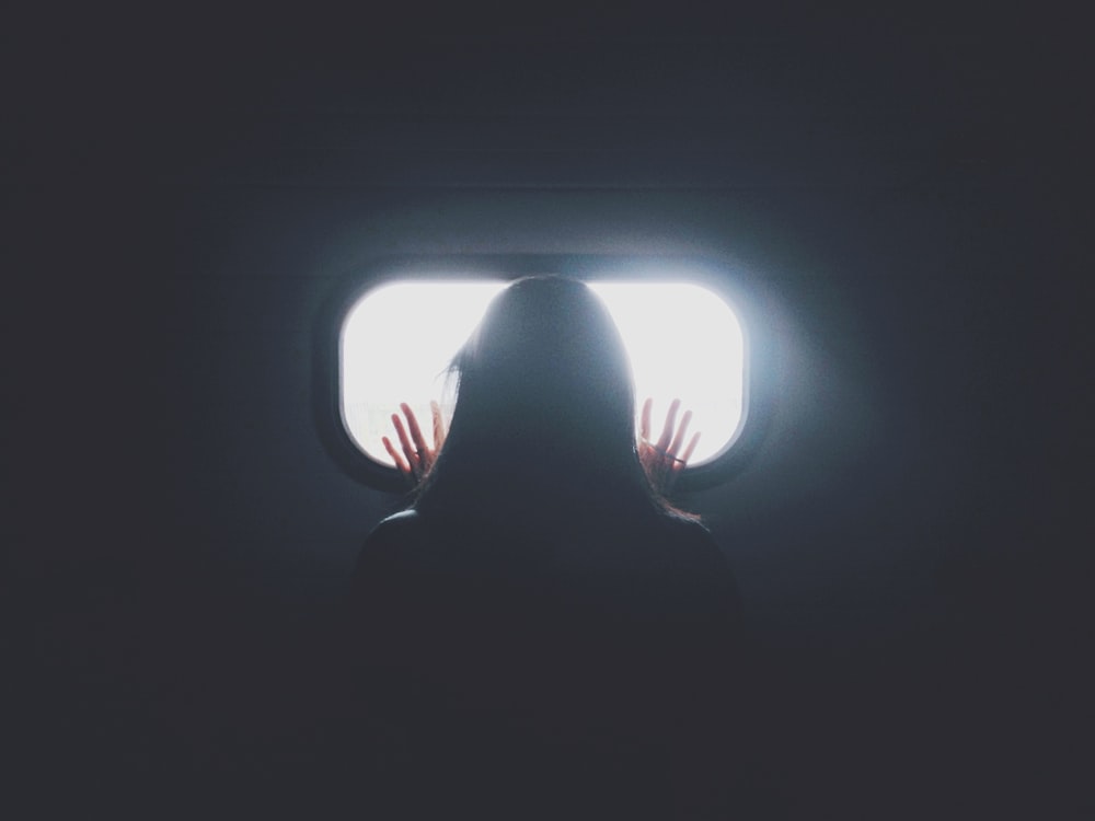 woman stand in front of glass mirror