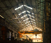 Wide shot of an industrial warehouse with overhead cranes equipped with Magnettrack technology.