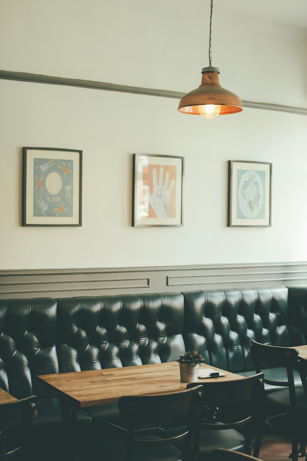 photo of dining set and leather sofa inside a room with pendant lamp