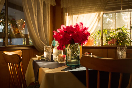 A cozy kitchen table set with handmade ceramic plates and linen napkins bathed in warm sunlight