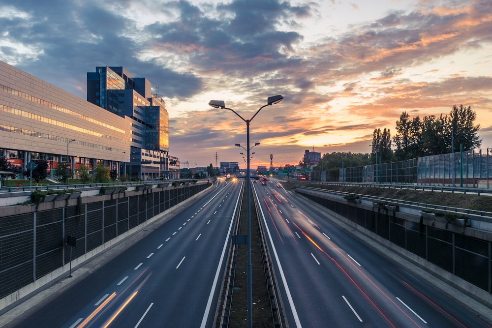 timelapse photo of 2-lane road under golden sky