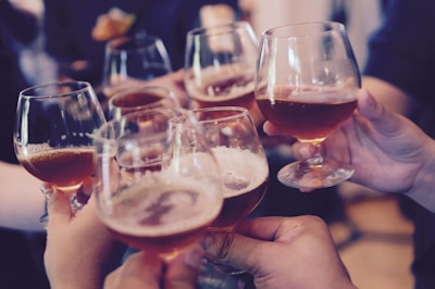 people holding beer glasses together in celebration