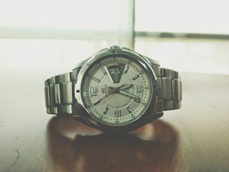 A sophisticated wristwatch resting on a polished wooden surface.