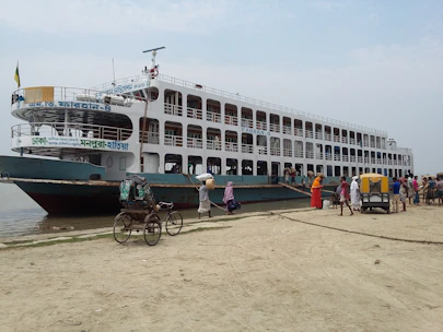 A ferry docked at a bustling port with travelers boarding and luggage being loaded.