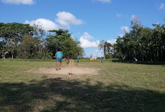 Group of kids practicing fielding drills during a summer cricket camp.