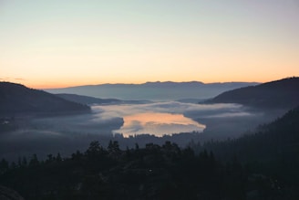 A serene landscape puzzle showing a misty mountain lake at sunrise.